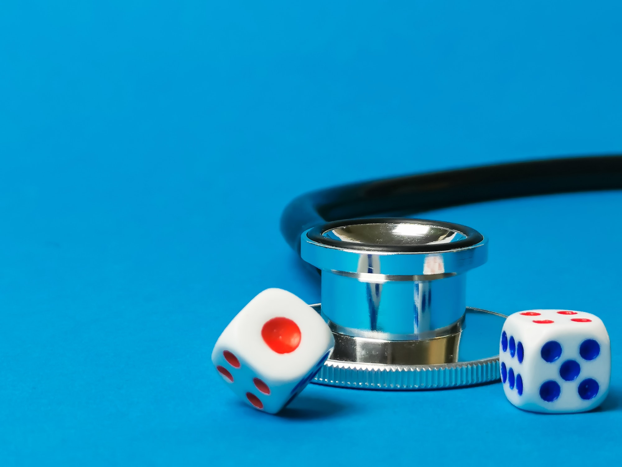 Close up photo of dices with stethoscope. Postcode lottery healthcare concept.