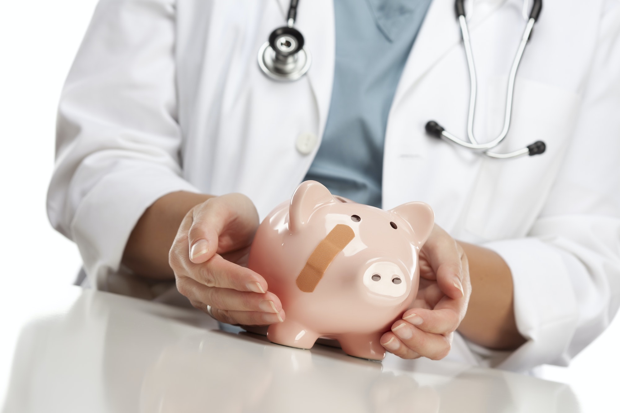 Doctor Holding Caring Hands on a Piggy Bank with Bandage